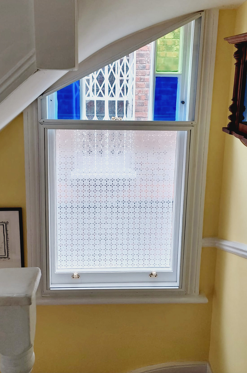 Window on stairs secondary glazed with stained glass